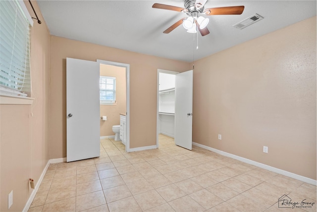 719 Kilpatrick St, Channelview, TX 77530 - unfurnished bedroom with baseboards, light tile patterned floors, a walk in closet, a ceiling fan, and ensuite bath