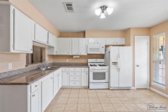 719 Kilpatrick St, Channelview, TX 77530 - kitchen with white appliances, a sink, white cabinets, and plenty of natural light