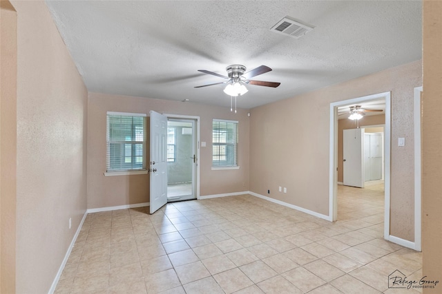 719 Kilpatrick St, Channelview, TX 77530 - empty room with a ceiling fan, a textured ceiling, light tile patterned floors, and baseboards