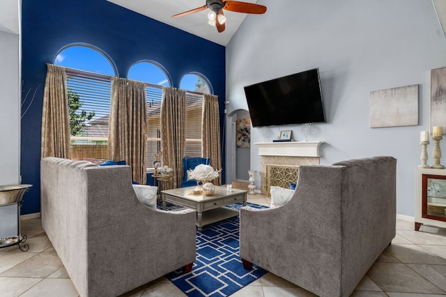 25993 Royal Emerald Ln, Kingwood, TX 77339 - living room with high vaulted ceiling, ceiling fan, tile patterned flooring, a fireplace, and arched walkways