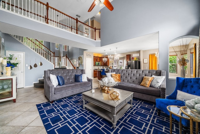 25993 Royal Emerald Ln, Kingwood, TX 77339 - living area with stairs, a towering ceiling, a ceiling fan, light tile patterned flooring, and baseboards