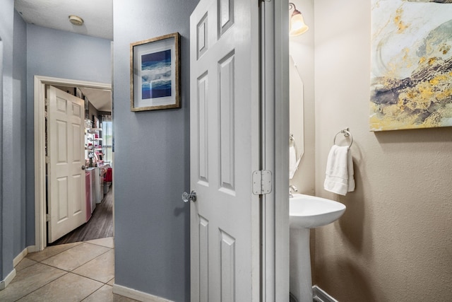 25993 Royal Emerald Ln, Kingwood, TX 77339 - bathroom featuring tile patterned floors, baseboards, and a sink