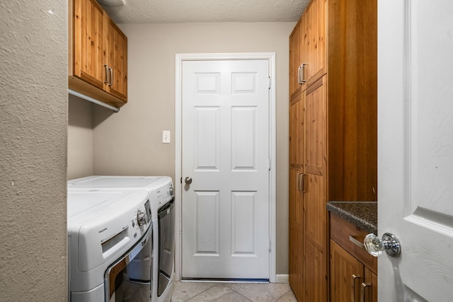 25993 Royal Emerald Ln, Kingwood, TX 77339 - laundry room featuring washing machine and clothes dryer, cabinet space, light tile patterned floors, and a textured ceiling