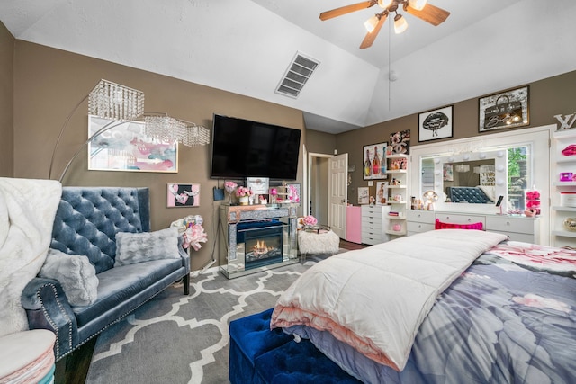 25993 Royal Emerald Ln, Kingwood, TX 77339 - carpeted bedroom featuring a glass covered fireplace, lofted ceiling, and a ceiling fan