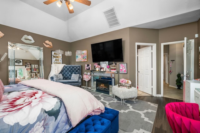 25993 Royal Emerald Ln, Kingwood, TX 77339 - bedroom featuring wood finished floors, a warm lit fireplace, and a ceiling fan