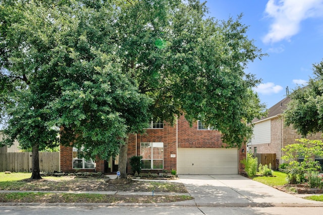 25993 Royal Emerald Ln, Kingwood, TX 77339 - obstructed view of property featuring driveway, a garage, and brick siding