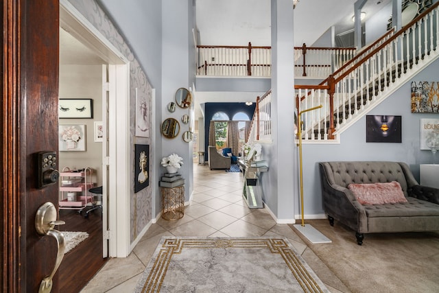 25993 Royal Emerald Ln, Kingwood, TX 77339 - tiled entryway with baseboards, a high ceiling, and stairs
