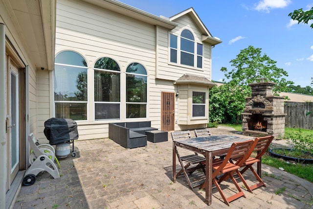 25993 Royal Emerald Ln, Kingwood, TX 77339 - view of patio featuring an outdoor stone fireplace, a grill, and outdoor dining area