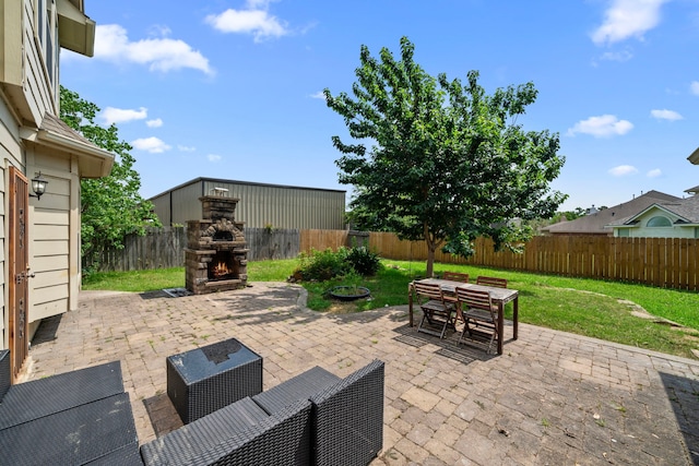 25993 Royal Emerald Ln, Kingwood, TX 77339 - view of patio featuring an outdoor stone fireplace and outdoor dining area