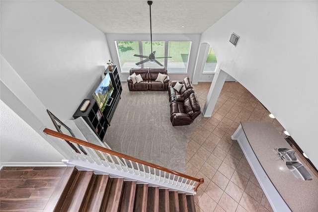 10307 Antelope Aly, Missouri City, TX 77459 - staircase with tile patterned floors, a textured ceiling, baseboards, and arched walkways