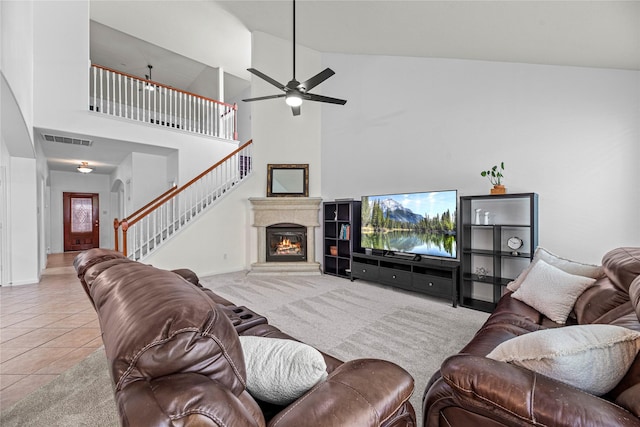 10307 Antelope Aly, Missouri City, TX 77459 - tiled living area with stairway, ceiling fan, a towering ceiling, a glass covered fireplace, and baseboards