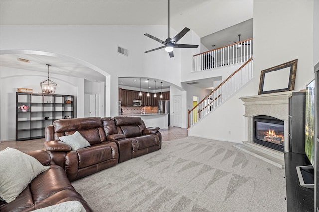 10307 Antelope Aly, Missouri City, TX 77459 - living area with ceiling fan, arched walkways, a glass covered fireplace, baseboards, and a towering ceiling