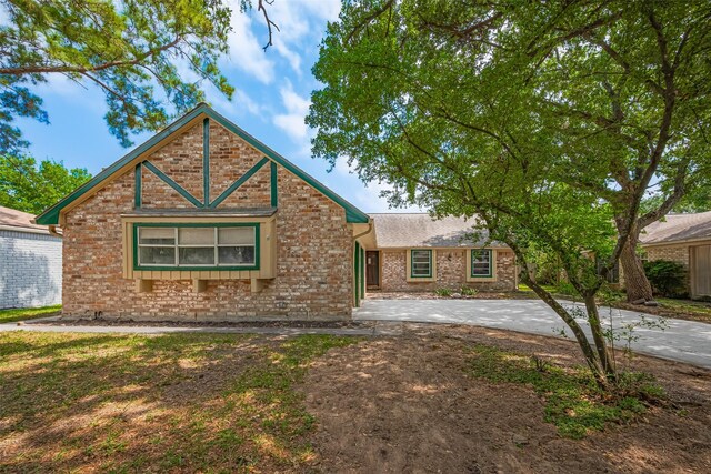 view of front of home with brick siding and concrete driveway