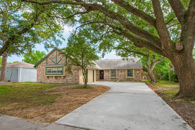 view of front of house featuring an attached garage, concrete driveway, brick siding, a shingled roof, and a front lawn