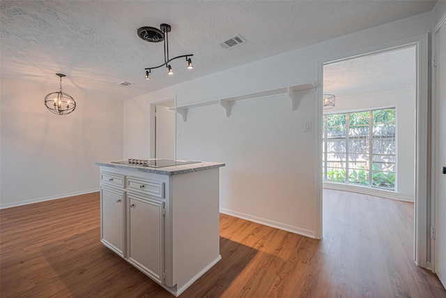 kitchen with black electric cooktop, open shelves, a textured ceiling, wood finished floors, and a chandelier