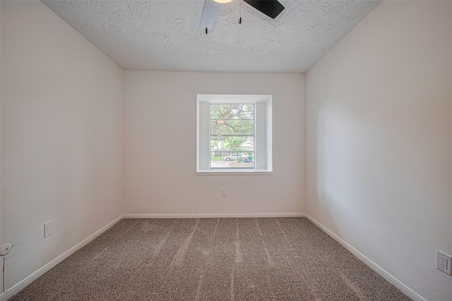 carpeted spare room featuring a textured ceiling, ceiling fan, and baseboards