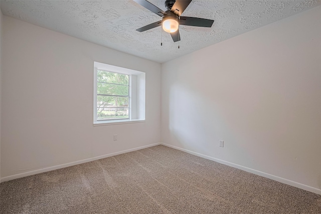 empty room with a textured ceiling, light colored carpet, baseboards, and ceiling fan