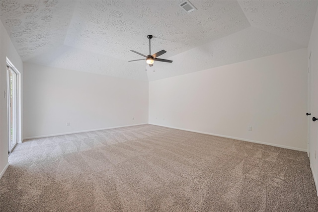 empty room with lofted ceiling, light carpet, a textured ceiling, ceiling fan, and baseboards