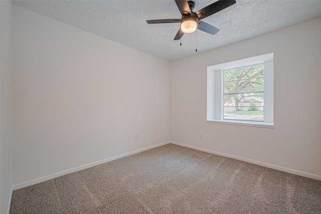 empty room featuring a textured ceiling, carpet floors, baseboards, and ceiling fan