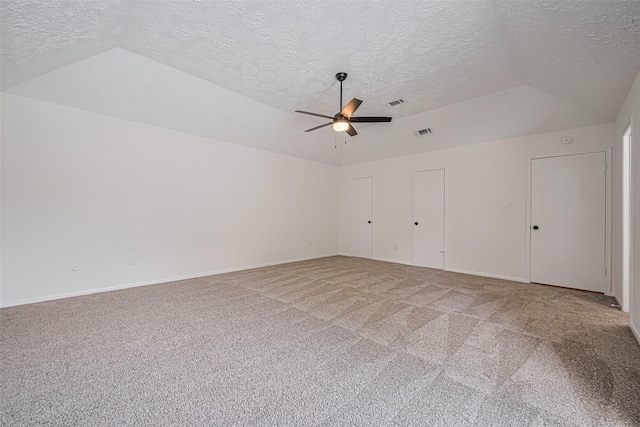 spare room featuring a textured ceiling, carpet, a ceiling fan, baseboards, and lofted ceiling