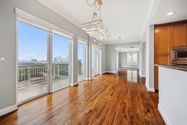 2520 Robinhood St Unit 1205, Houston, TX 77005 - unfurnished dining area with a chandelier, dark wood-type flooring, baseboards, and crown molding