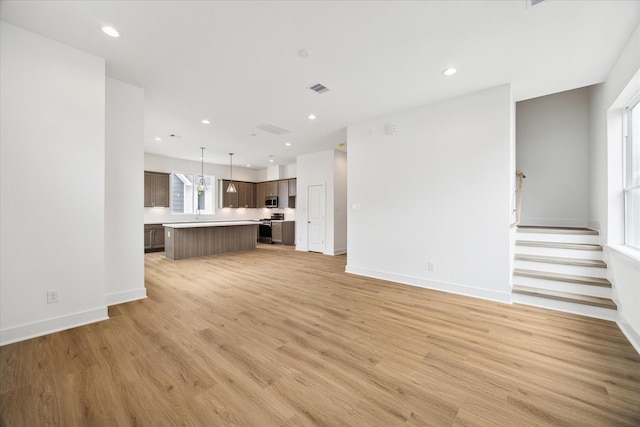 1650 W Tidwell Rd, Houston, TX 77091 - unfurnished living room with light wood finished floors, recessed lighting, baseboards, and stairway
