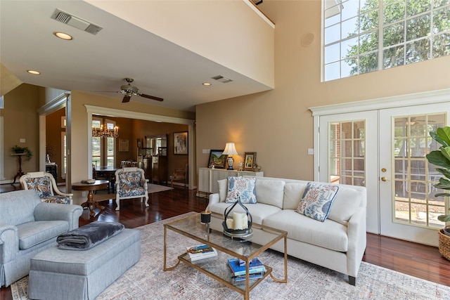 51 Oak Hollow Cir, Lake Jackson, TX 77566 - living room featuring a chandelier, wood finished floors, a ceiling fan, french doors, and a high ceiling