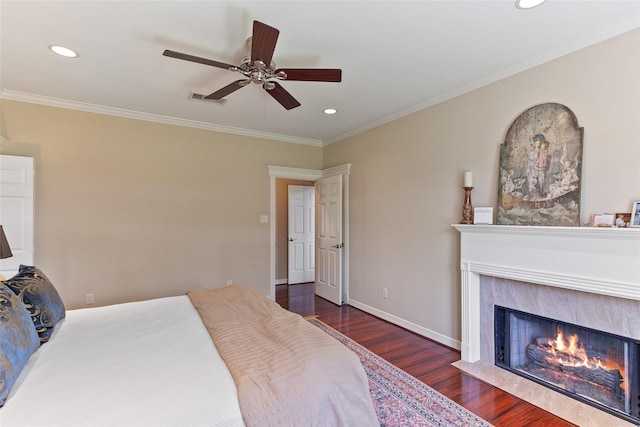 51 Oak Hollow Cir, Lake Jackson, TX 77566 - bedroom featuring wood finished floors, crown molding, recessed lighting, a tiled fireplace, and ceiling fan