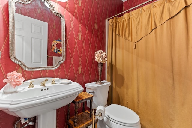 51 Oak Hollow Cir, Lake Jackson, TX 77566 - bathroom with wallpapered walls, toilet, a shower with curtain, and a sink