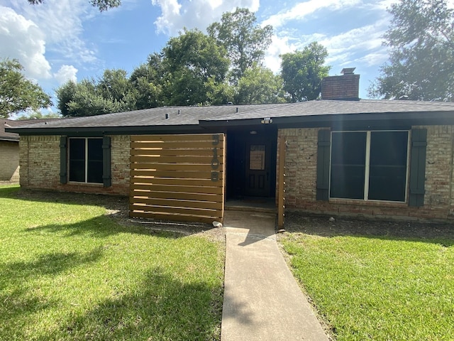 5108 Longshadow Dr, Dickinson, TX 77539 - ranch-style house featuring a front lawn, a chimney, brick siding, and a shingled roof