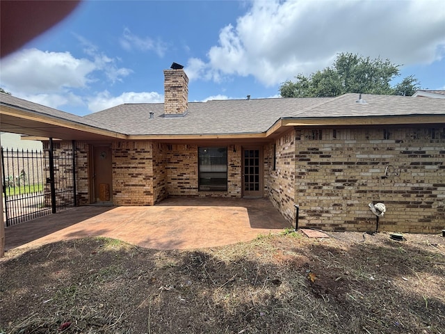 405 Tudor Ct, Deer Park, TX 77536 - back of property with brick siding, a patio, a chimney, and roof with shingles