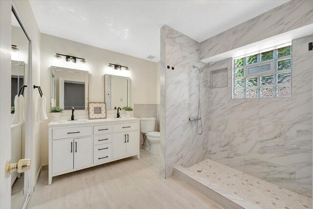11710 Brettwood Cir, Houston, TX 77089 - full bathroom with toilet, a marble finish shower, double vanity, and tile walls