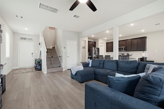 21626 Sage Landing Ln, Katy, TX 77449 - living room featuring stairs, light wood finished floors, ceiling fan, baseboards, and recessed lighting