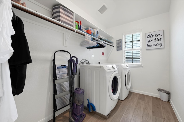 21626 Sage Landing Ln, Katy, TX 77449 - laundry room with washer and clothes dryer, light wood finished floors, and baseboards