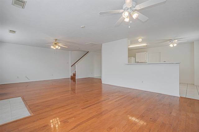 8223 Golf Green Cir, Houston, TX 77036 - unfurnished living room featuring ceiling fan, light wood-style floors, and stairs