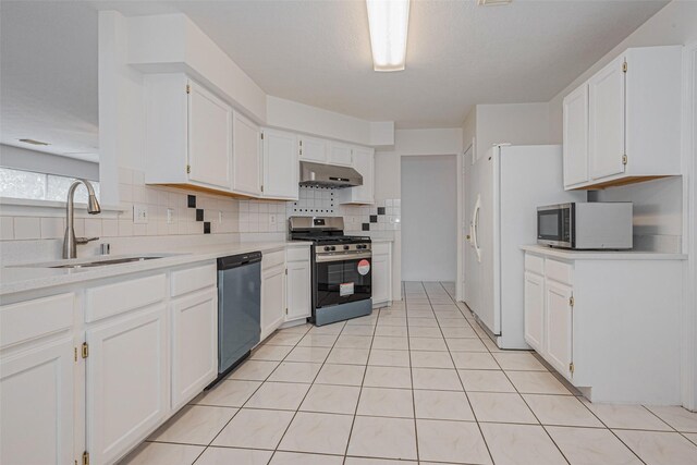 8223 Golf Green Cir, Houston, TX 77036 - kitchen with appliances with stainless steel finishes, a sink, under cabinet range hood, white cabinets, and tasteful backsplash