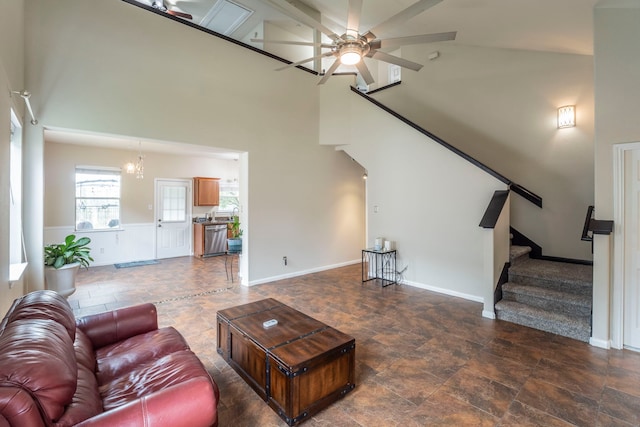 3911 Falvel Cove Dr, Spring, TX 77388 - living room featuring a towering ceiling, stone finish floors, ceiling fan, stairs, and a chandelier
