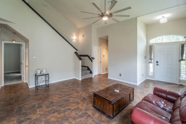 3911 Falvel Cove Dr, Spring, TX 77388 - living room featuring a high ceiling, healthy amount of natural light, a ceiling fan, stairs, and baseboards