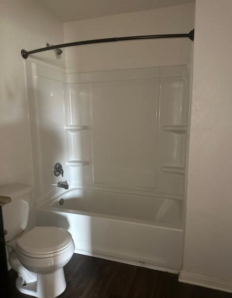 15215 Snug Harbor Way, Von Ormy, TX 78073 - bathroom featuring toilet, wood finished floors, and shower / bathtub combination