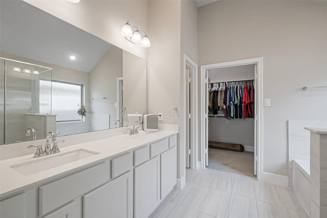 26415 Polaris Rise Ln, Richmond, TX 77406 - bathroom with lofted ceiling, double vanity, a bath, a shower stall, and baseboards