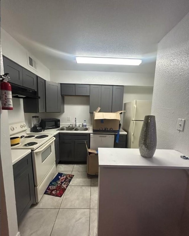 5625 Antoine Dr Unit 705, Houston, TX 77091 - kitchen featuring white appliances, a sink, under cabinet range hood, light tile patterned flooring, and light countertops