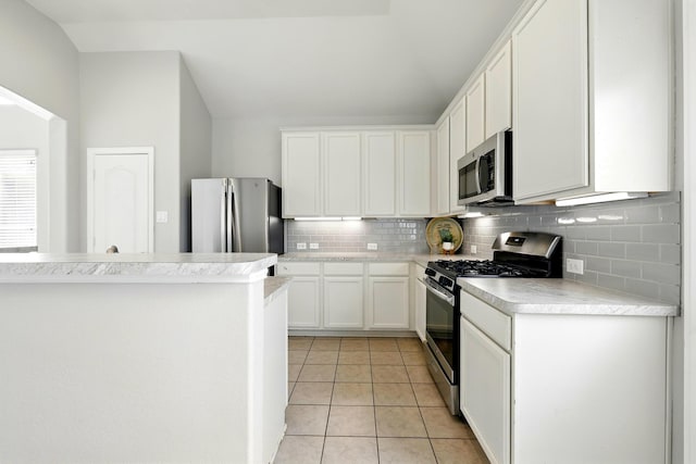 32719 Oak Heights Ln, Brookshire, TX 77423 - kitchen with stainless steel appliances, backsplash, light countertops, white cabinets, and lofted ceiling