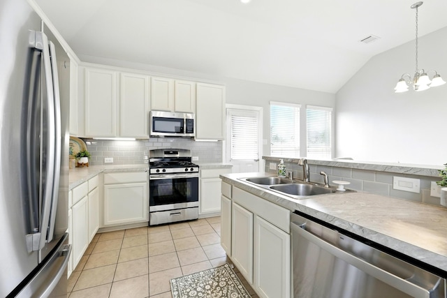 32719 Oak Heights Ln, Brookshire, TX 77423 - kitchen with appliances with stainless steel finishes, a sink, lofted ceiling, tasteful backsplash, and light tile patterned floors