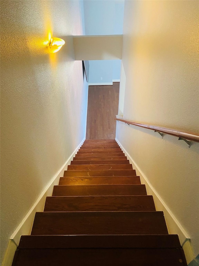 3123 Dallas St, Houston, TX 77003 - stairway featuring wood finished floors, a textured wall, and baseboards