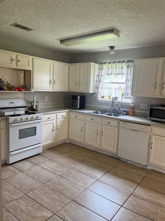 12147 Swords Creek Rd, Houston, TX 77067 - kitchen with white appliances, a sink, a textured ceiling, light tile patterned floors, and light countertops