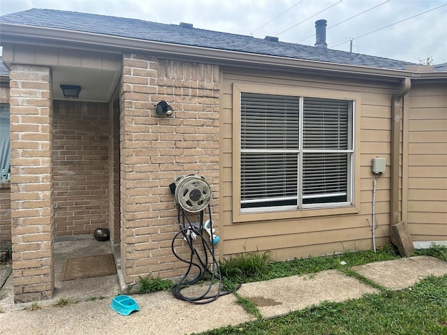 12147 Swords Creek Rd, Houston, TX 77067 - exterior view of roof with shingles, brick siding, gutters, and a downspout