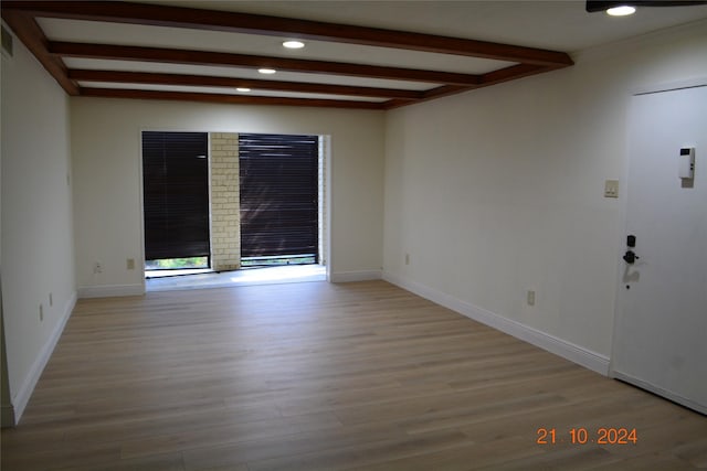 7575 Katy Fwy Unit 9, Houston, TX 77024 - empty room featuring beam ceiling, wood finished floors, recessed lighting, and baseboards