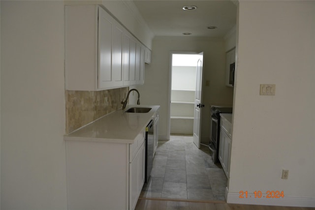 7575 Katy Fwy Unit 9, Houston, TX 77024 - kitchen featuring a sink, white cabinetry, appliances with stainless steel finishes, light countertops, and ornamental molding