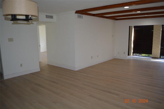 7575 Katy Fwy Unit 9, Houston, TX 77024 - empty room featuring wood finished floors, baseboards, beamed ceiling, and recessed lighting