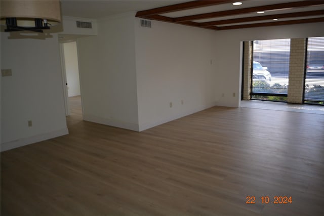 7575 Katy Fwy Unit 9, Houston, TX 77024 - unfurnished room with light wood-type flooring, beamed ceiling, baseboards, and recessed lighting